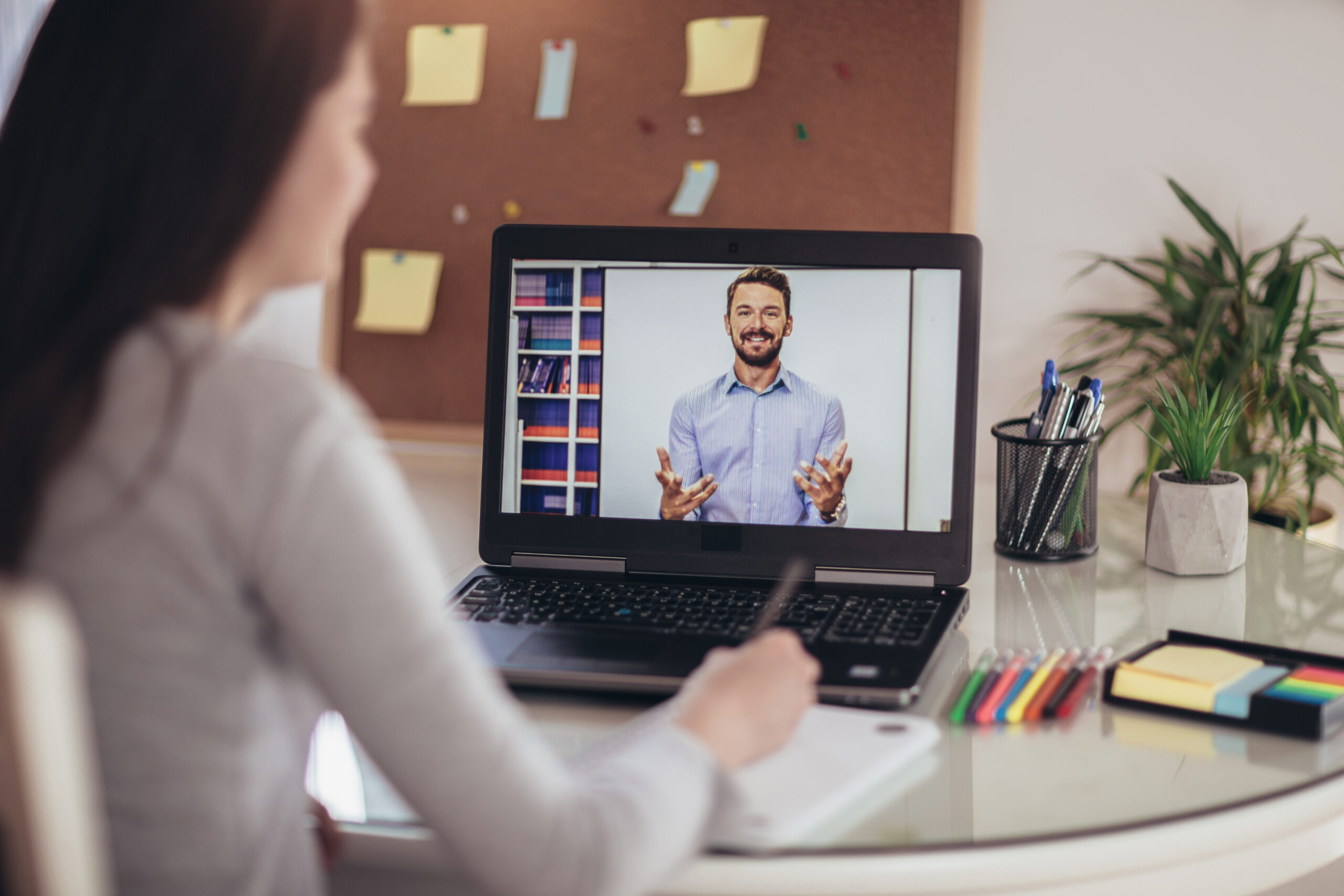 woman sitting at a small table attending a video conference